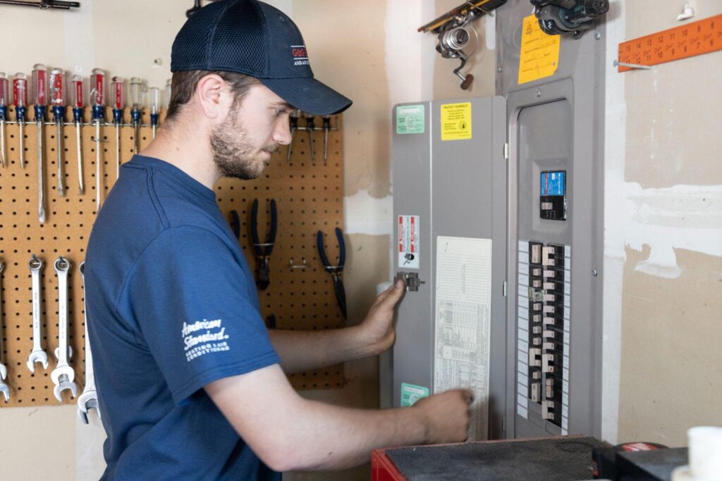 G&G Heating and Air Conditioning service technician inspecting an electrical panel that may need to be upgraded.