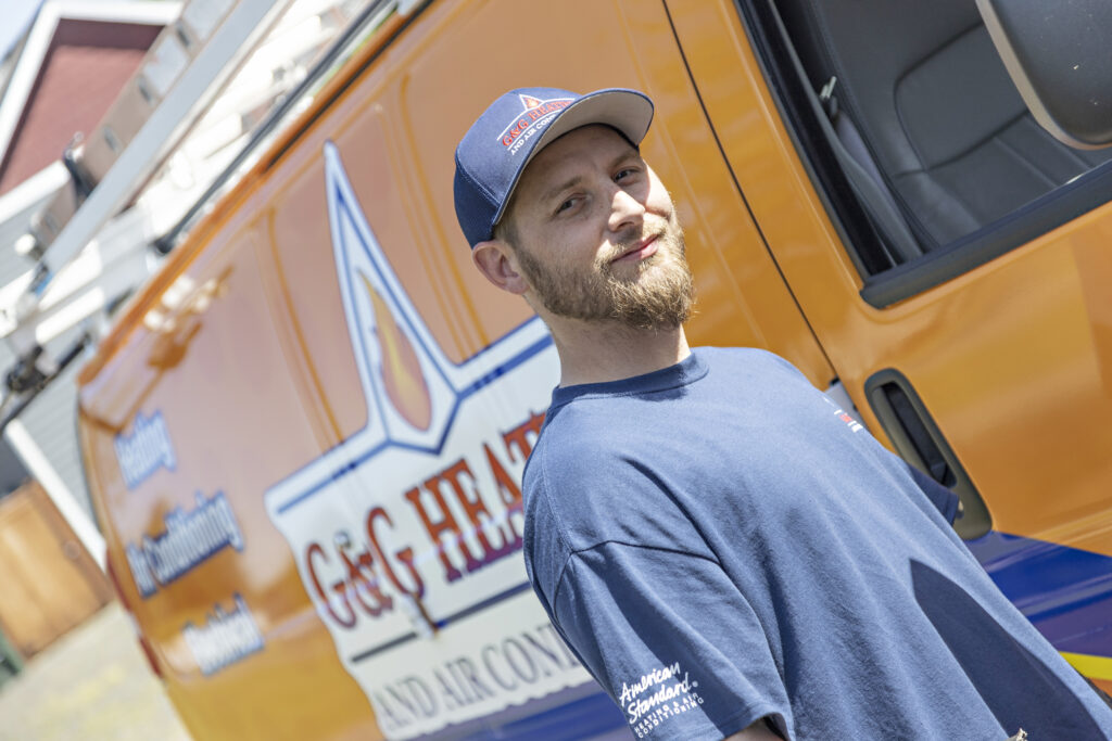 G&G Heating and Air Conditioning Tech in front of Van
