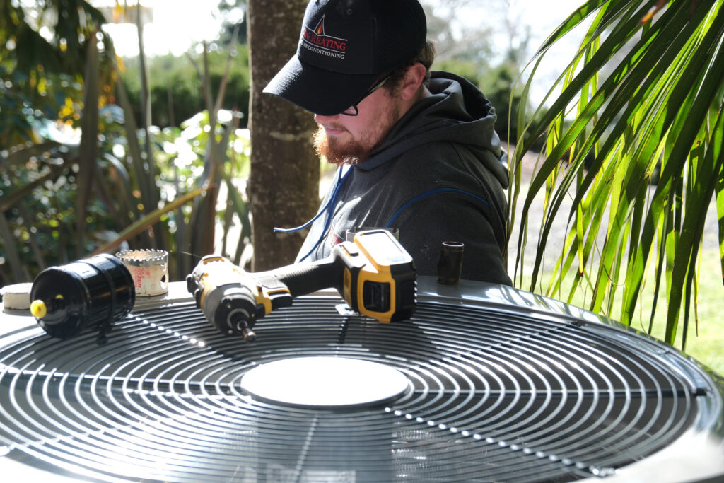 HVAC tech doing maintenance on AC unit